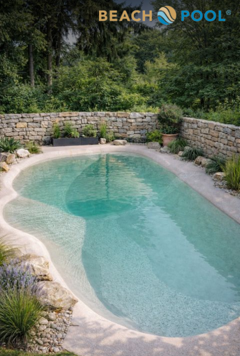 A natural-style swimming pool with clear water, surrounded by stone and lush greenery, sits in a peaceful garden with a stone wall and plants around the edges. Featured in the Luxury Pool Gallery, BEACH POOL is written at the top of the image.